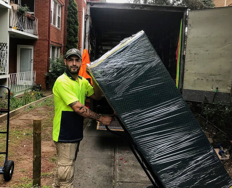 one man and a truck. removalist with a trolley and fridge